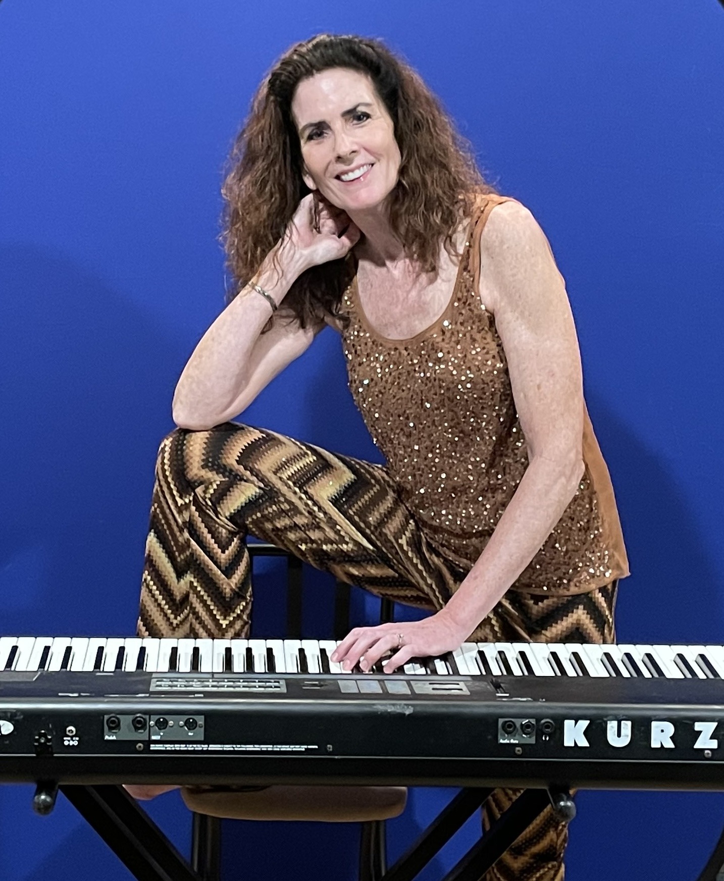 A woman sitting at a piano posing for a picture